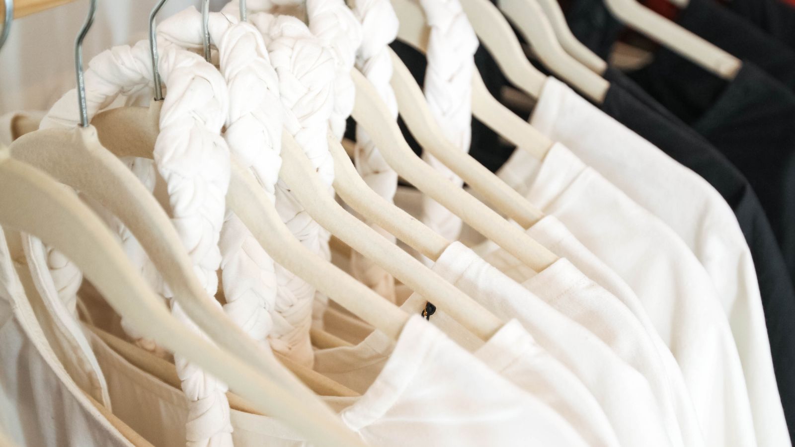 Light shirts on wooden hangers in neutral tones